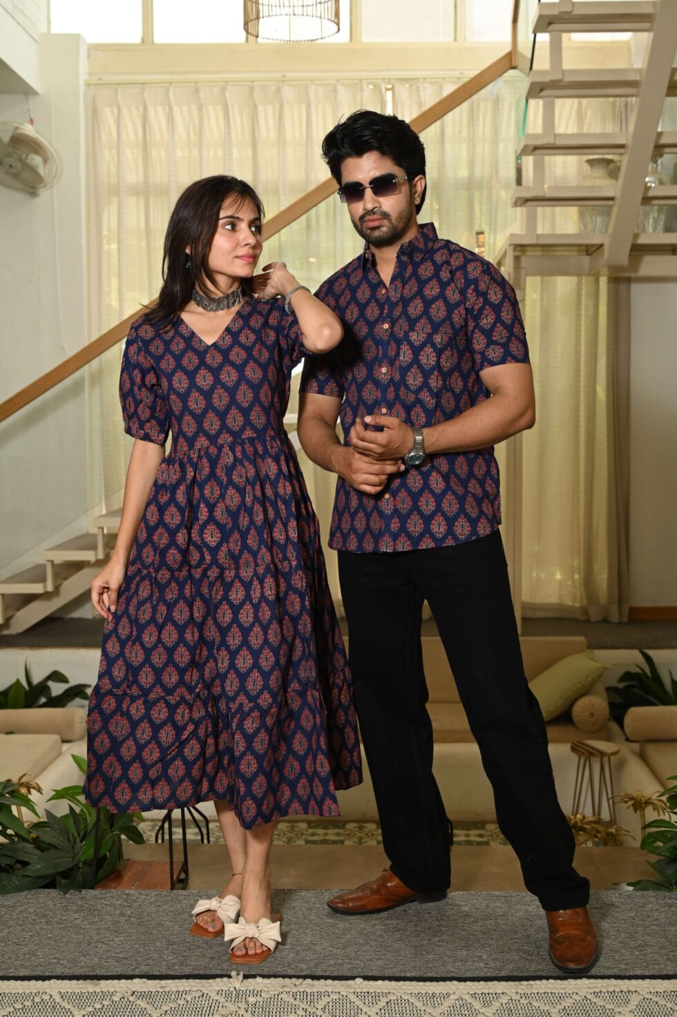 Woman in navy blue Anarkali midi dress posing with man in matching printed shirt