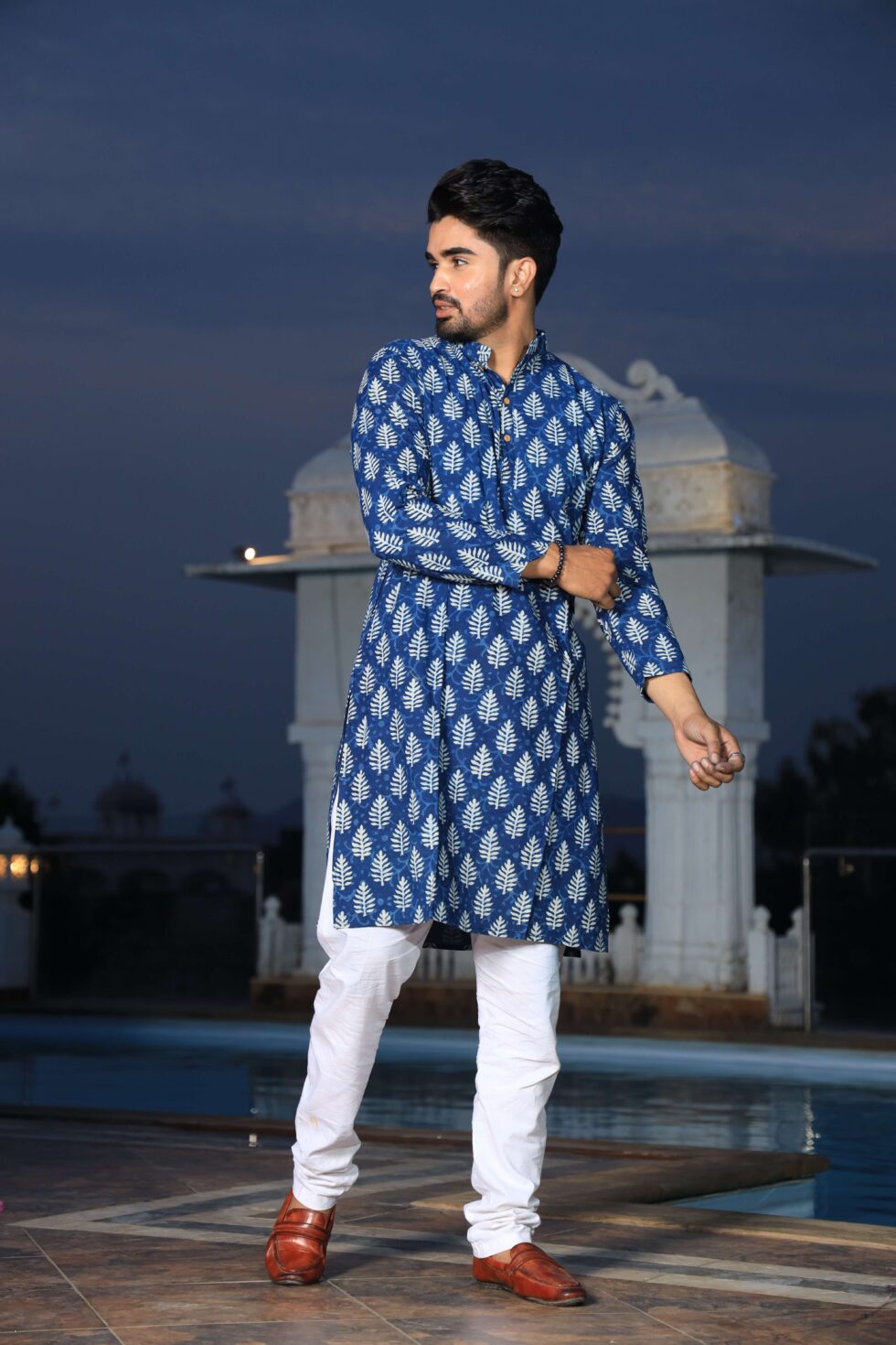 Model wearing the handcrafted kurta for men, posing in front of a traditional Indian backdrop